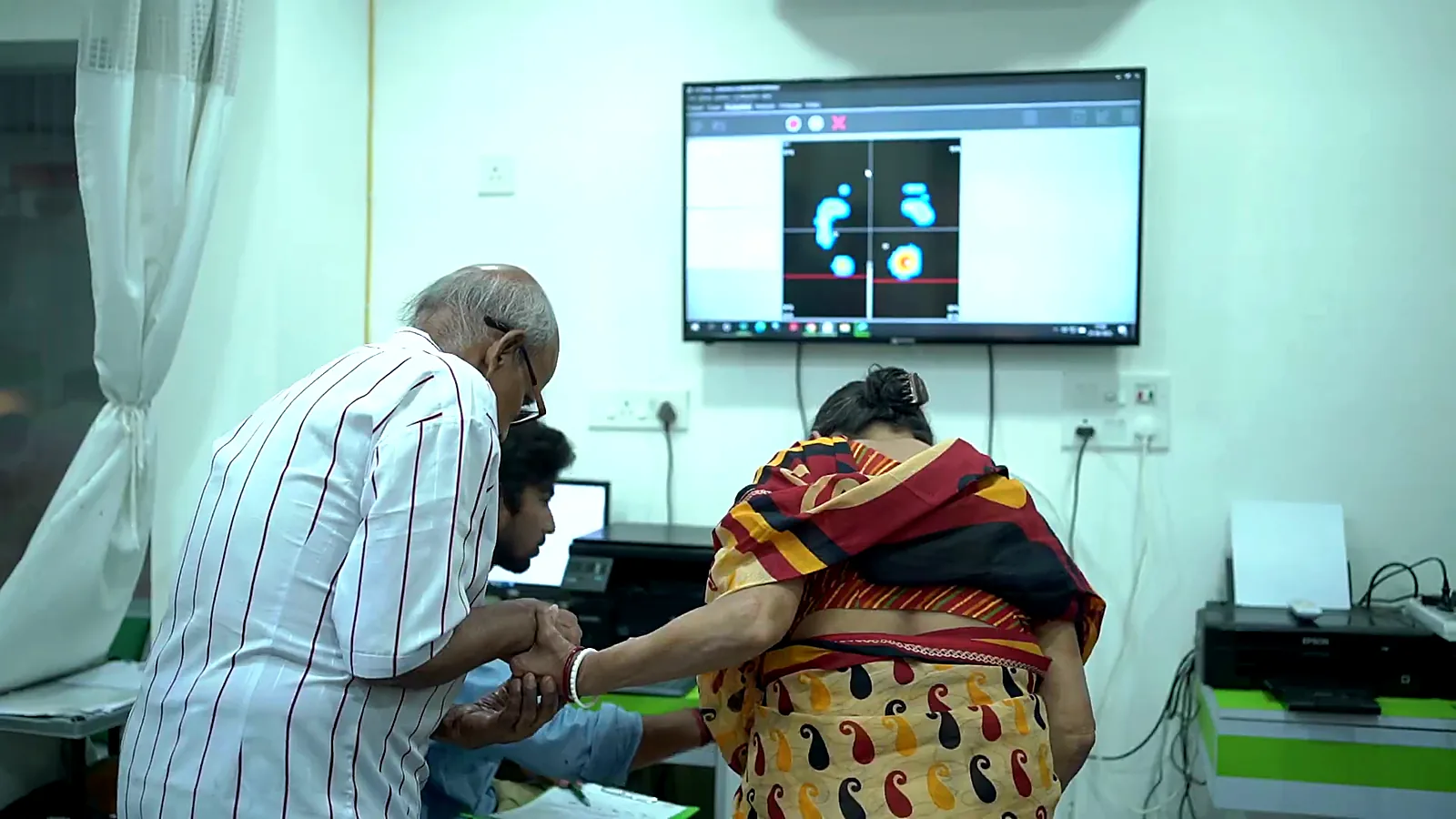 CuraFoot doctor examining a patient's foot with the foot scan on screen